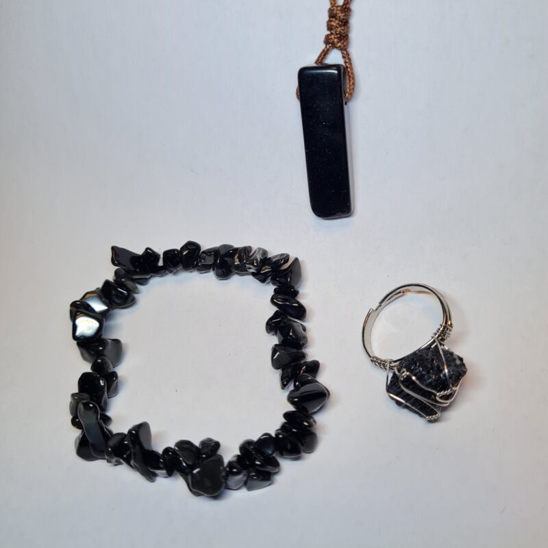 Obsidian Schmuckset mit Armband, Anhänger und Ring auf weißem Hintergrund