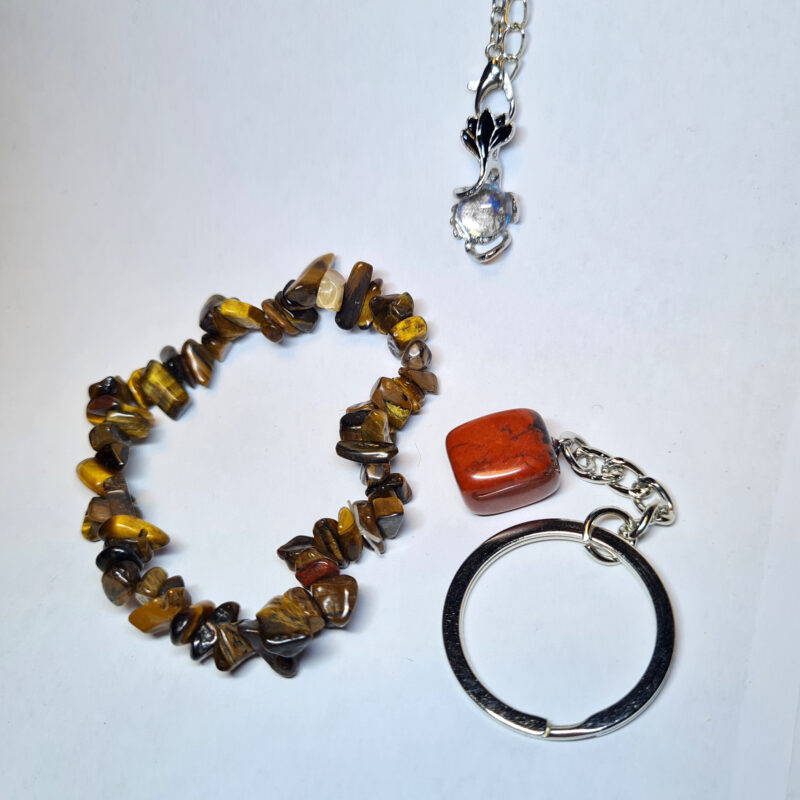 Set mit Tigerauge Armband, rotem Jaspis Schlüsselanhänger und Mondstein Kette auf weißem Hintergrund
